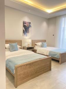 a bedroom with two beds and a painting on the wall at Spacious new 2 bedroom Apt-in amazing location B9 in Riyadh +20 photos