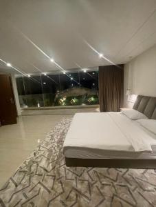 um quarto com uma cama grande e uma janela grande em راحتي هوم em Al Rass