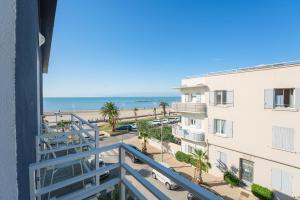 a view of the beach from the balcony of a building at Hôtel Café Miramar in Le Grau-du-Roi