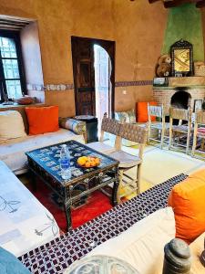 a living room with a couch and a table with oranges on it at Dar Boumida in Lalla Takerkoust