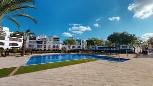 una piscina frente a un edificio con palmeras en Casa Esturion J-A Murcia Holiday Rentals Property, en Roldán