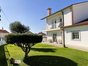 ein großes weißes Haus mit einem Baum im Hof in der Unterkunft CRALS - Casa da Guilheta in Esposende