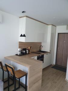 a kitchen with a counter and chairs in a room at Smilties apartamentai in Juodkrantė