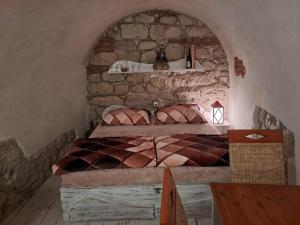 a bedroom with a bed in a stone wall at NAD STARÝM SKLEPEM in Valtice