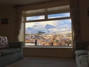 a window in a living room with a view of a mountain at Cairn Shiel in Achnasheen