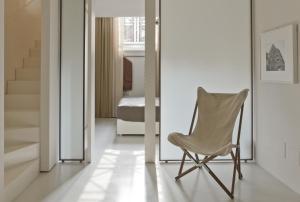 a chair in a room with a bedroom at Suitime in Milan