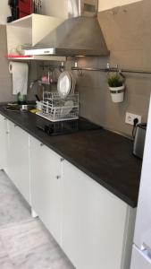 a kitchen with white cabinets and a black counter top at The Spot Central Hostel in Seville