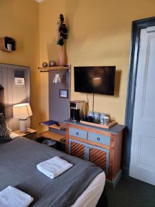 um quarto com uma cama e uma secretária com uma televisão em The Residence - NO 57 em Edimburgo