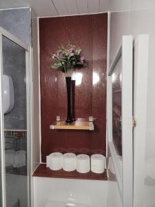 a shelf with a vase with flowers in a bathroom at The Residence - NO 57 in Edinburgh