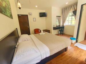 um quarto com uma grande cama branca num quarto em Hillview Inn Cameron Highlands PROMO em Tanah Rata