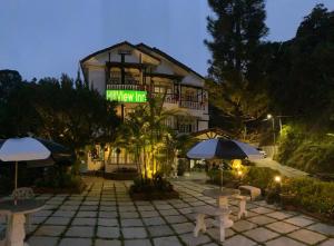 un gran edificio con sombrillas y mesas delante de él en Hillview Inn Cameron Highlands PROMO, en Tanah Rata