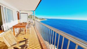 balcón con mesa, sillas y vistas al océano en Familidays 03 Del Far, en Salou