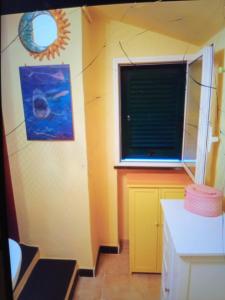 een keuken met een raam en een gele muur bij Soledad in Bonassola