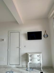 Habitación blanca con tocador blanco y TV en la pared en The RoofPort, en San Felice Circeo