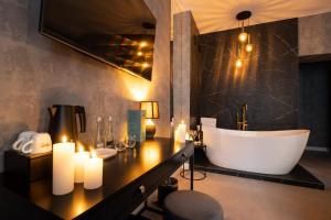 a bathroom with a tub and a sink with candles at Apartamenty Drewno i Ogień in Olsztyn