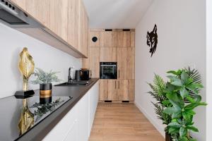 a kitchen with white walls and wooden cabinets at Apartament Morskie Oko Odkryj Zakopane in Zakopane
