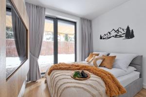 1 dormitorio con cama y ventana grande en Apartament Morskie Oko Odkryj Zakopane, en Zakopane