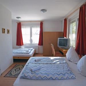 a living room with two beds and a tv at Balaton Vendégház Fonyód in Fonyód