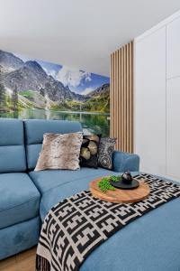 niebieska kanapa ze stołem w salonie w obiekcie Apartament Morskie Oko Odkryj Zakopane w Zakopanem