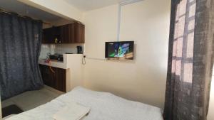 mały pokój z łóżkiem i telewizorem na ścianie w obiekcie Ruth's Haven w mieście Kidono
