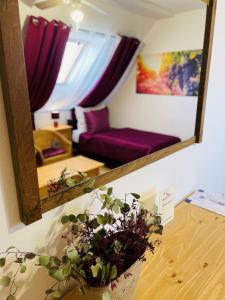 a mirror reflecting a living room with a purple couch at Hotel Marcincak*** in Mikulov