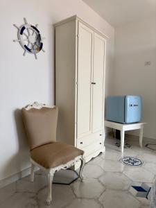 Cette chambre comprend une chaise, une armoire et une télévision. dans l'établissement The RoofPort, à San Felice Circeo