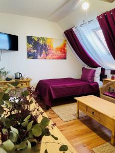 a living room with a purple bed and a couch at Hotel Marcincak*** in Mikulov