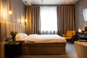 um quarto com uma cama e uma cadeira amarela em Apartamenty Drewno i Ogień em Olsztyn
