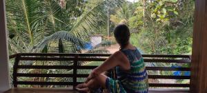 a woman sitting on a bench looking out a window at MARARI CASA LINDA HOMESTAY in Mararikulam +22 photos