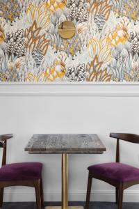 a table with two purple chairs in front of a wall at The Pheasant Inn in Grange Over Sands