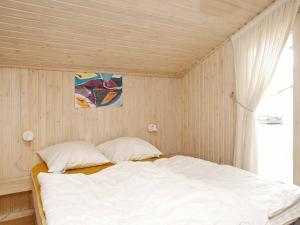 a bed in a room with a wooden ceiling at 8 person holiday home in Pandrup in Blokhus