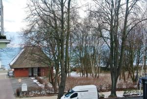 ein weißer Van vor einem kleinen Gebäude geparkt in der Unterkunft Ferienwohnungen am Rosenhof in Kühlungsborn