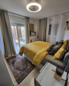 a bedroom with a bed with a yellow blanket and a table at Apartamento Mark in Santa Pola
