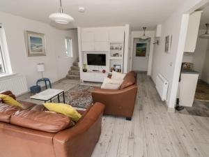a living room with two couches and a television at 38 Carrowhubbock Holiday Village in Enniscrone