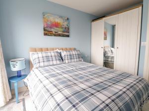 um quarto com uma cama com um cobertor xadrez em 38 Carrowhubbock Holiday Village em Enniscrone