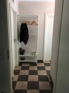 a hallway with an empty refrigerator with a checkerboard floor at Räuberlager 15 in Dammbach