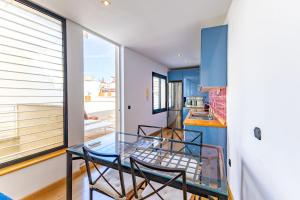 een glazen tafel en stoelen in een keuken met blauwe kasten bij Alcazar Pool Villa by Valcambre in Sevilla