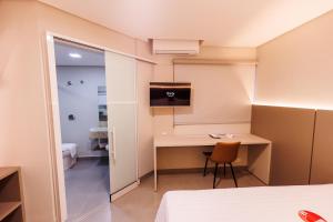 a hotel room with a desk and a tv at Tonello Business Hotel in Campo Mourão