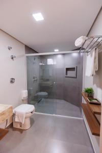 a bathroom with a shower stall and a toilet at Tonello Business Hotel in Campo Mourão