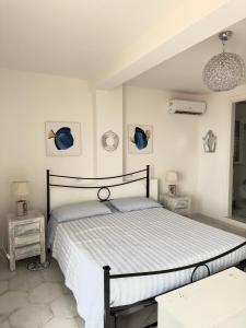 a white bedroom with a bed and two tables at The RoofPort in San Felice Circeo