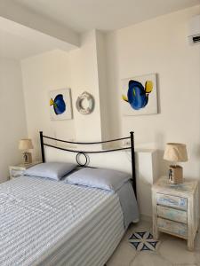 1 dormitorio con 1 cama y 2 cuadros en la pared en The RoofPort, en San Felice Circeo