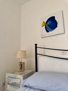 1 dormitorio con 1 cama y una foto de pescado en la pared en The RoofPort, en San Felice Circeo