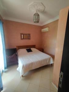 um quarto com uma cama branca num quarto em la Paysanne by Souna em Marrakech