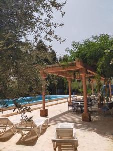 een groep stoelen en tafels naast een zwembad bij la Paysanne by Souna in Marrakesh