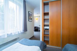 - une chambre avec un placard, un lit et une fenêtre dans l'établissement Warsaw Apartments - Apartamenty Wilanów, à Varsovie