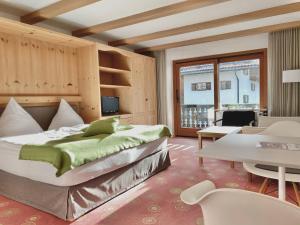 een slaapkamer met een groot bed en een tafel bij Sonnhof Apartments Tegernsee - zentral und perfekt für Urlaub & Arbeit in Bad Wiessee