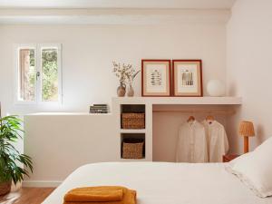 a bedroom with a white bed and white walls at Les Canes 2 in Aiguafreda