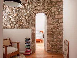 a room with a stone wall with an archway at Les Canes 2 in Aiguafreda