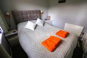 1 dormitorio con 1 cama con 2 toallas de color naranja en Cosy double room in peaceful location, Ballachulish nr Glencoe Highlands en Ballachulish