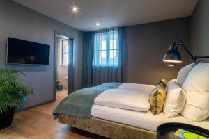 a bedroom with a large bed and a tv at Goldammer Aschaffenburg in Aschaffenburg